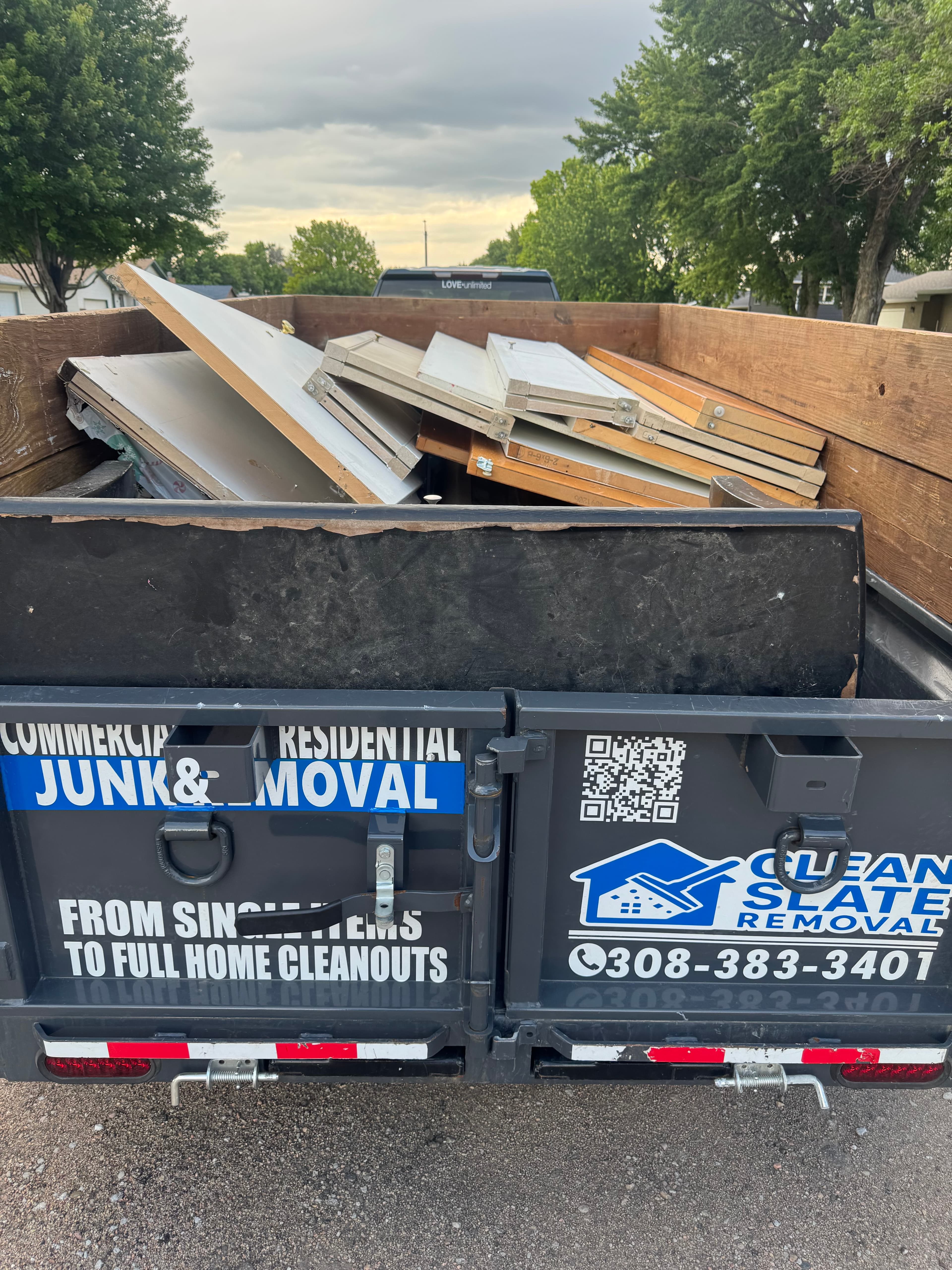 Clean Slate Removal trailer loaded with discarded wooden doors and panels for disposal.